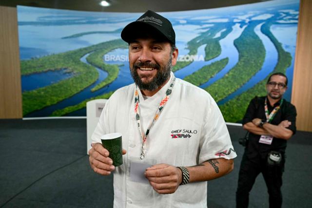 Brazilian Chef Saulo Jennings hands out water to journalists during the COP30 UN Climate Change Conference in Belem, Para state, Brazil on November 19, 2025. (Photo by Pablo PORCIUNCULA / AFP)