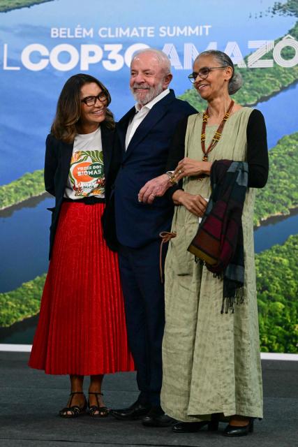 Brazil's President Luiz Inacio Lula da Silva (C) smiles alongside his wife, First Lady Rosangela "Janja" da Silva (L), and Environment Minister Marina Silva during a press conference at the COP30 UN Climate Change Conference in Belem, Para state, Brazil, on November 19, 2025. Brazilian President Luiz Inacio Lula da Silva hit the corridors of COP30 in Belem on Wednesday, in a push to land a deal at the UN climate talks as nations remained divided over contentious issues. (Photo by Pablo PORCIUNCULA / AFP)
