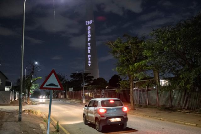 The Glasgow Actions Team project a message calling for debt justice onto the Sentech Tower in Johannesburg on November 19, 2025, ahead of the G20 leaders’ summit. (Photo by EMMANUEL CROSET / AFP)
