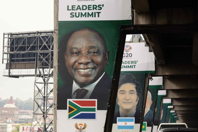 A banner of South Africa's President Cyril Ramaphosa (L), who is also the president of the G20 for 2025, is displayed on a pillar of an highway overpass in Johannesburg on November 20, 2025. (Photo by GIANLUIGI GUERCIA / AFP)