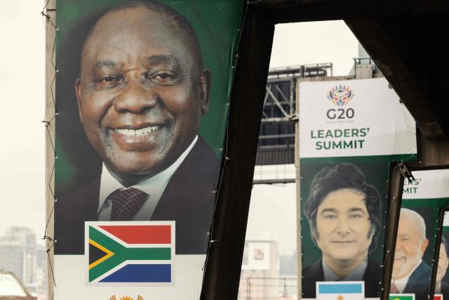 A banner of South Africa's President Cyril Ramaphosa (L), who is also the president of the G20 for 2025, is displayed on a pillar of an highway overpass in Johannesburg on November 20, 2025. (Photo by GIANLUIGI GUERCIA / AFP)