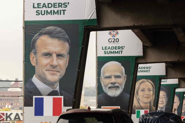 Banners of (from L to R) France's President Emmanuel Macron, India's Prime Minister Narendra Modi, Italy's Prime Minister Giorgia Meloni, is displayed on pillars of an highway overpass in Johannesburg on November 20, 2025. (Photo by GIANLUIGI GUERCIA / AFP)