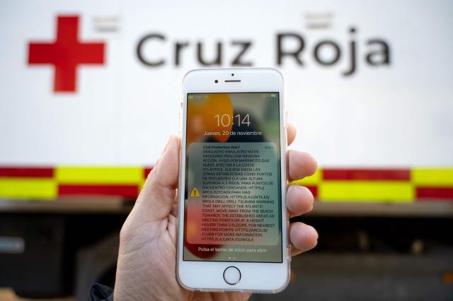 A smartphone displays a tsunami warning during the Respuesta25 tsunami drill in Cadiz, on November 20, 2025. Around 20,000 persons took part in the 'Respuesta25' simulation, aimed at assessing institutional coordination, evacuation times and the effectiveness of warning systems before a tidal wave. (Photo by Jorge GUERRERO / AFP)