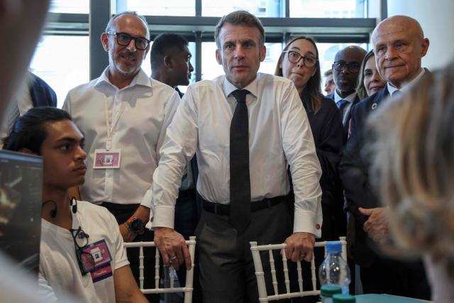 France's President Emmanuel Macron (C) meets with participants at an artificial intelligence (AI) festival at the Caudan Arts Center during his visit to Mauritius, at the Caudan Waterfront in Port Louis on November 20, 2025. (Photo by Ludovic MARIN / AFP)