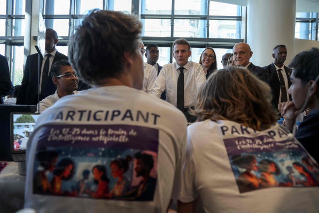 France's President Emmanuel Macron (C) meets with participants at an artificial intelligence (AI) festival at the Caudan Arts Center during his visit to Mauritius, at the Caudan Waterfront in Port Louis on November 20, 2025. (Photo by Ludovic MARIN / AFP)