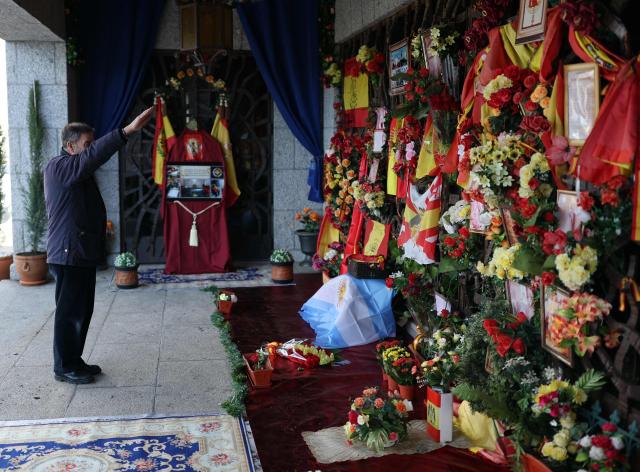 A man performs the fascist salute to pay his respect to late Spanish dictator Francisco Franco, 50 years after his death, in front of his tomb at the Mingorrubio cemetery in El Pardo, northern Madrid, on November 20, 2025. Following his exhumation from the Valley of Cuelgamuros in 2019, Franco's remains were interred in El Pardo alongside his wife Carmen Polo, drawing annual visits from those nostalgic for his regime. Spain's leftist government on November 19, 2025 announced 480 new events to be held this year to mark the 50th anniversary of the death of right-wing dictator Francisco Franco and the restoration of democracy. Franco died on November 20, 1975, aged 82, after ruling Spain with an iron fist for nearly four decades. (Photo by Thomas COEX / AFP)