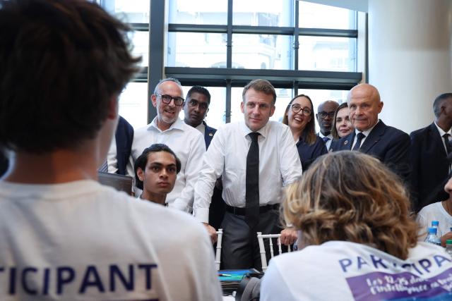 TOPSHOT - France's President Emmanuel Macron (C) meets with participants at an artificial intelligence (AI) festival at the Caudan Arts Center during his visit to Mauritius, at the Caudan Waterfront in Port Louis on November 20, 2025. (Photo by Ludovic MARIN / AFP)