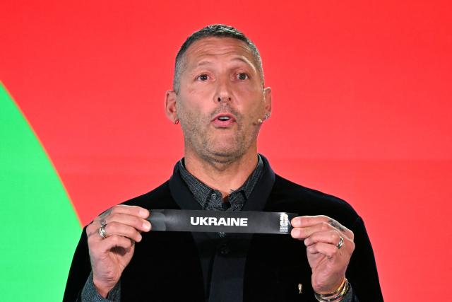 Italian former player Marco Materazzi shows the paper slip of Ukraine during the 2026 FIFA World Cup European Play-Off draw at the FIFA's Home of Football in Zurich on November 20, 2025. (Photo by Fabrice COFFRINI / AFP)