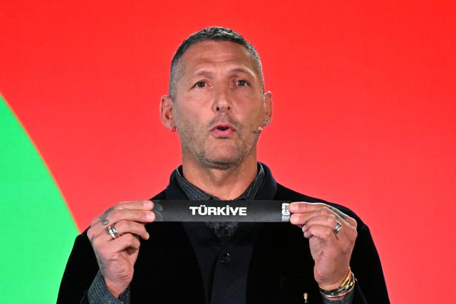 Italian former player Marco Materazzi shows the paper slip of Turkey during the 2026 FIFA World Cup European Play-Off draw at the FIFA's Home of Football in Zurich on November 20, 2025. (Photo by Fabrice COFFRINI / AFP)