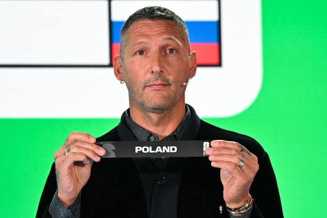Italian former player Marco Materazzi shows the paper slip of Poland during the 2026 FIFA World Cup European Play-Off draw at the FIFA's Home of Football in Zurich on November 20, 2025. (Photo by Fabrice COFFRINI / AFP)