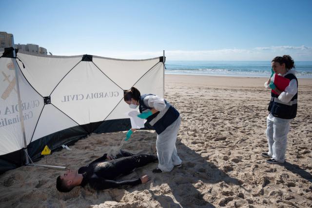 A participant lies on the beach during the Respuesta25 tsunami drill in Cadiz, on November 20, 2025. Around 20,000 persons took part in the 'Respuesta25' simulation, aimed at assessing institutional coordination, evacuation times and the effectiveness of warning systems before a tidal wave. (Photo by Jorge GUERRERO / AFP)