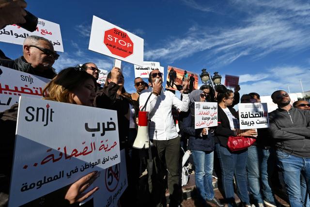 Tunisian protesters, including journalists, hold placards calling for freedom of the press and expression during a demonstration outside the prime minister's office in Tunis on November 20, 2025. Dozens of Tunisians including journalists protested to denounce attacks on press freedom, with some saying the authorities' crackdown on media was "unprecedented" since the country's 2011 revolution. (Photo by FETHI BELAID / AFP)