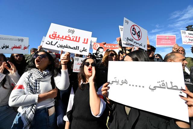 Tunisian protesters, including journalists, hold placards calling for freedom of the press and expression during a demonstration outside the prime minister's office in Tunis on November 20, 2025. Dozens of Tunisians including journalists protested to denounce attacks on press freedom, with some saying the authorities' crackdown on media was "unprecedented" since the country's 2011 revolution. (Photo by FETHI BELAID / AFP)