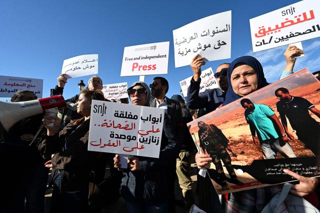 Tunisian protesters, including journalists, hold placards calling for freedom of the press and expression during a demonstration outside the prime minister's office in Tunis on November 20, 2025. Dozens of Tunisians including journalists protested to denounce attacks on press freedom, with some saying the authorities' crackdown on media was "unprecedented" since the country's 2011 revolution. (Photo by FETHI BELAID / AFP)
