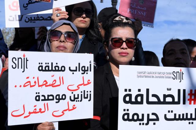Tunisian protesters, including journalists, hold placards calling for freedom of the press and expression during a demonstration outside the prime minister's office in Tunis on November 20, 2025. Dozens of Tunisians including journalists protested to denounce attacks on press freedom, with some saying the authorities' crackdown on media was "unprecedented" since the country's 2011 revolution. (Photo by FETHI BELAID / AFP)