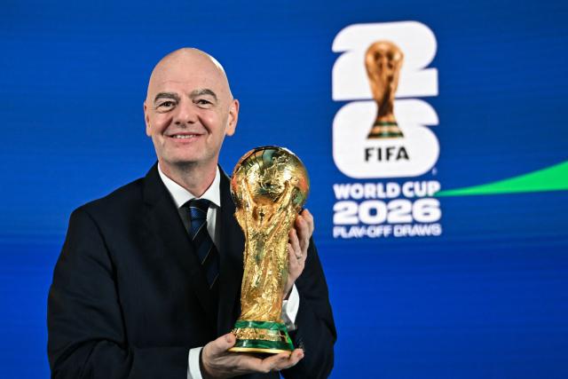FIFA President Gianni Infantino poses with the 2026 FIFA World Cup trophy following the 2026 FIFA World Cup European Play-Off draw at the FIFA's Home of Football in Zurich on November 20, 2025. (Photo by Fabrice COFFRINI / AFP)