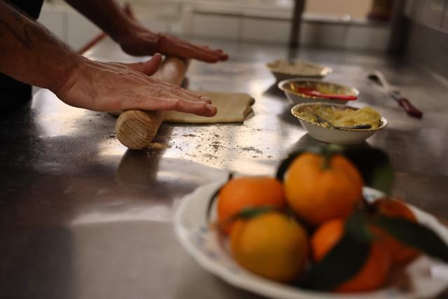 Chef Romain Rontodi of the Rosette et Charlot restaurant cooks Corsican clementines to prepare a dessert at the restaurant in Ajaccio, on the French Mediterranean island of Corsica, on November 15, 2025. (Photo by Pascal POCHARD-CASABIANCA / AFP)