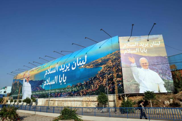 A man walks past a giant billboard of Pope Leo XIV on the highway that leads to Beirut's international airport on November 20, 2025. The Pope will travel to Turkey and Lebanon in a six-day trip beginning late November, his first since becoming head of the Catholic Church. (Photo by Anwar AMRO / AFP)