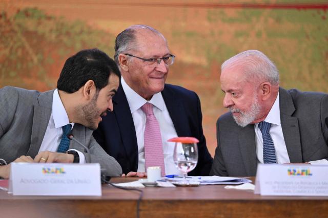 (FILES) Brazilian President Luiz Inacio Lula da Silva (R), his Vice President and Minister of Industry and Trade Geraldo Alckmin (C) and Attorney General of the Union Jorge Messias talk during the signing of a new agreement to repair the damage caused by the Fundao dam collapse tragedy in Mariana, Minas Gerais State, at a ceremony at the Planalto Palace in Brasilia, on October 25, 2024. Brazilian President Luiz Inacio Lula da Silva nominated a trusted ally, lawyer Jorge Messias, to the Supreme Court on November 20, 2025, under scrutiny from the United States since the trial for coup plotting against former President Jair Bolsonaro. (Photo by EVARISTO SA / AFP)
