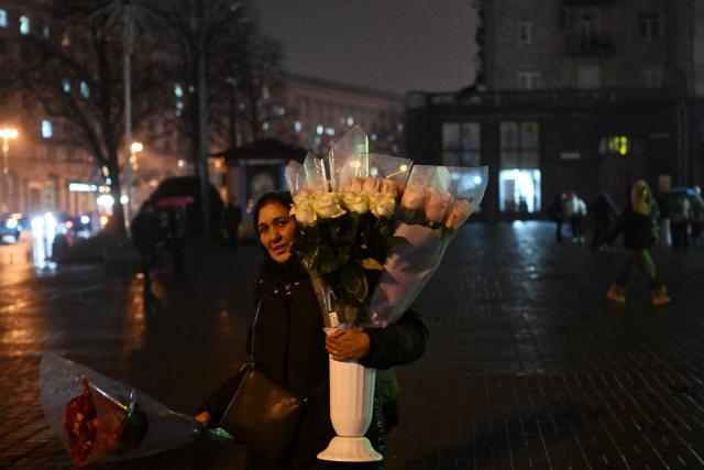 A woman sells flowers on a street in Kyiv on November 20, 2025, amid the Russian invasion of Ukraine. (Photo by Sergei GAPON / AFP)