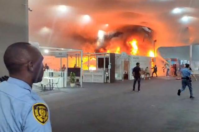 This screen grab taken from AFPTV video footage shows emergency crews battling a fire that broke out at a pavilion inside the venue of the COP30 UN Climate Change Conference in Belem, Para state, Brazil, on November 20, 2025. A fire erupted at a pavilion inside the venue of the UN's climate talks in Brazil on Thursday, prompting panicked delegates to run for the exits, AFP journalists said. Emergency crews rushed to try to put out the blaze as smoke engulfed the corridor. (Photo by AFPTV / AFP)