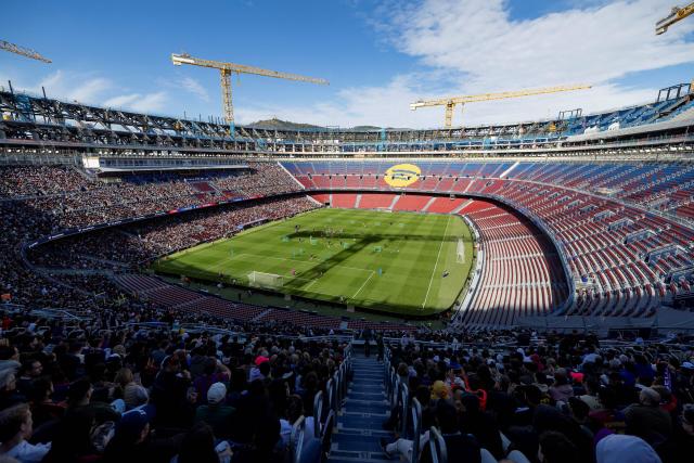 (FILES) Barcelona supporters attend FC Barcelona open training session, the first at the Camp Nou stadium since the beginning of the construction works more than two years ago, on November 7, 2025 in Barcelona. After two and a half years, FC Barcelona will return on November 23, 2025 to the Camp Nou, its mythical stadium still under construction and whose renovation should embody the renewed ambitions of the Catalan giant. (Photo by Josep LAGO / AFP)