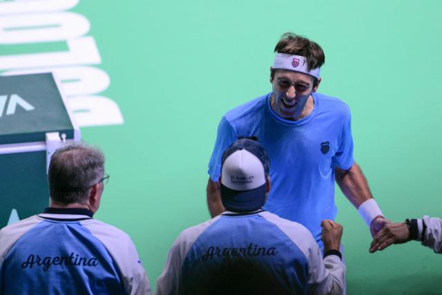 Argentina's Tomas Martin Etcheverry celebrates with teammates after winning his Davis Cup men's singles quarter finals tennis match against Germany's Jan-Lennard Struff, at the Super Tennis Arena, in Bologna, northen Italy, on November 20, 2025. (Photo by Tiziana FABI / AFP)