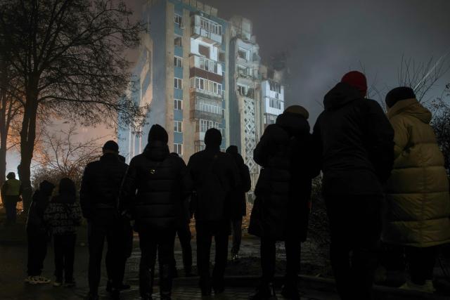 Local residents stand at the site of a heavily damaged residential building following an air attack in Ternopil on November 20, 2025, amid the Russian invasion of Ukraine. Ukrainian president said on November 20, 2025 that 22 people were still missing in the western city of Ternopil, a day after a Russian strike there killed at least 26 people, including three children. (Photo by Vladyslav Musiienko / AFP)