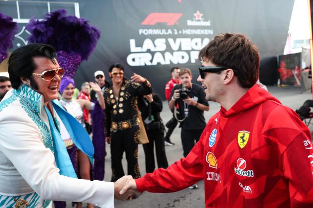 Ferrari's Monegasque driver Charles Leclerc is greeted by an Elvis Presley impersonator as he arrives ahead of the first practice session for the Las Vegas Formula One Grand Prix at the Las Vegas Strip Circuit in Las Vegas, Nevada, on November 20, 2025. (Photo by Patrick T. Fallon / AFP)