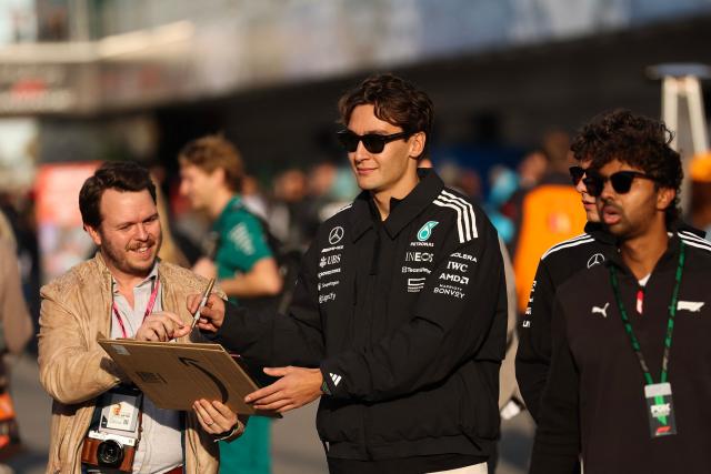 Mercedes' British driver George Russell signs an autograph in the paddock ahead of the first practice session for the Las Vegas Formula One Grand Prix at the Las Vegas Strip Circuit in Las Vegas, Nevada, on November 20, 2025. (Photo by Patrick T. Fallon / AFP)