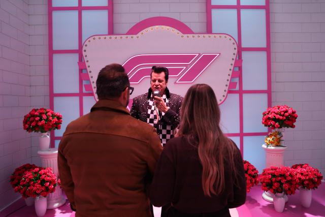 A couple renews their wedding vows with an Elvis Presley impersonator at the "F1 Neon Wedding Chapel" ahead of the first practice session for the Las Vegas Formula One Grand Prix at the Las Vegas Strip Circuit in Las Vegas, Nevada, on November 20, 2025. (Photo by Patrick T. Fallon / AFP)