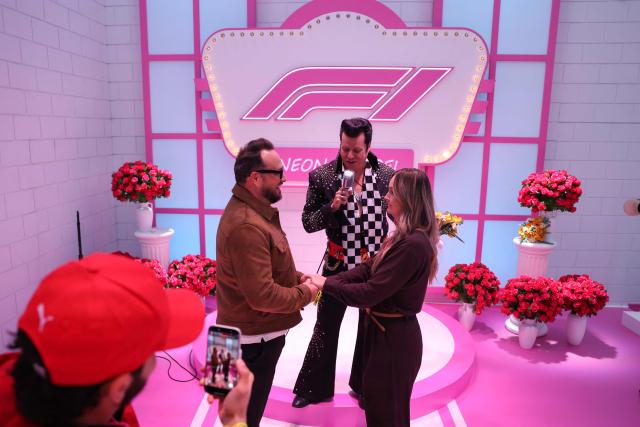 A couple renews their wedding vows with an Elvis Presley impersonator at the "F1 Neon Wedding Chapel" ahead of the first practice session for the Las Vegas Formula One Grand Prix at the Las Vegas Strip Circuit in Las Vegas, Nevada, on November 20, 2025. (Photo by Patrick T. Fallon / AFP)