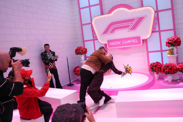 A couple renews their wedding vows with an Elvis Presley impersonator at the "F1 Neon Wedding Chapel" ahead of the first practice session for the Las Vegas Formula One Grand Prix at the Las Vegas Strip Circuit in Las Vegas, Nevada, on November 20, 2025. (Photo by Patrick T. Fallon / AFP)