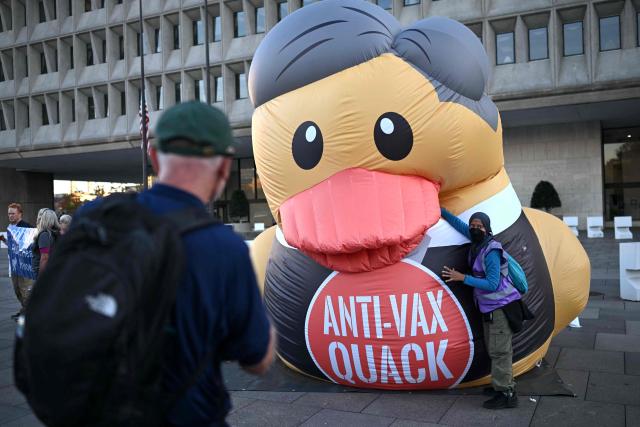 (FILES) A protester takes a photo of an inflatable duck during a march calling for the removal of US Secretary of Health and Human Services Robert F. Kennedy Jr. outside of the Department of Health and Human services (HHS) in Washington, DC, on November 5, 2025. The US health agency has updated its official website to reflect the vaccine skepticism of a senior Trump official, a move that medical and public health experts widely condemned. The Centers for Disease Control and Prevention (CDC) late on November 19, 2025 revised its site with language that undermines its previous, scientifically grounded position that immunizations do not cause the developmental disability autism. (Photo by ANDREW CABALLERO-REYNOLDS / AFP)