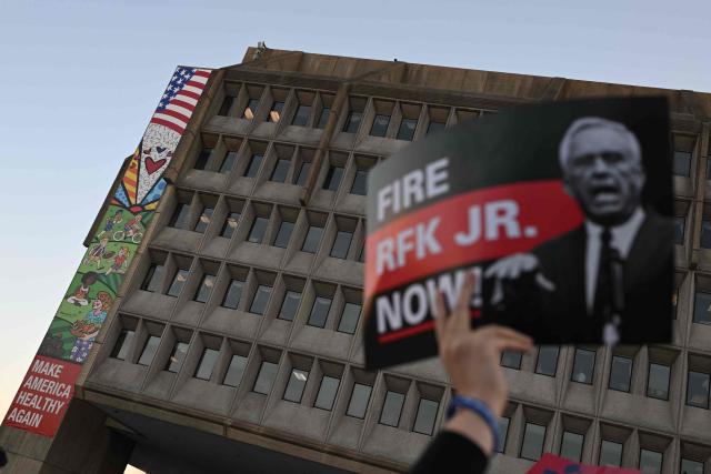 (FILES) A protester holds up a sign during a march calling for the removal of US Secretary of Health and Human Services Robert F. Kennedy Jr. outside of the Department of Health and Human services (HHS) in Washington, DC, on November 5, 2025. The US health agency has updated its official website to reflect the vaccine skepticism of a senior Trump official, a move that medical and public health experts widely condemned. The Centers for Disease Control and Prevention (CDC) late on November 19, 2025 revised its site with language that undermines its previous, scientifically grounded position that immunizations do not cause the developmental disability autism. (Photo by ANDREW CABALLERO-REYNOLDS / AFP)
