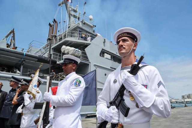 Crew members of the Champlain vessel stand at attention in the harbour near Port Louis on November 21, 2025. (Photo by Ludovic MARIN / AFP)