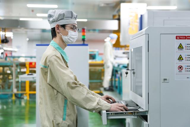 A man works on the production of electronic circuit base materials for high-performance computing, AI servers, 5G communications, and aerospace applications at Jiangxi Shengyi Technology in Jiujiang, central China's Jiangxi province on November 20, 2025. (Photo by AFP) / China OUT