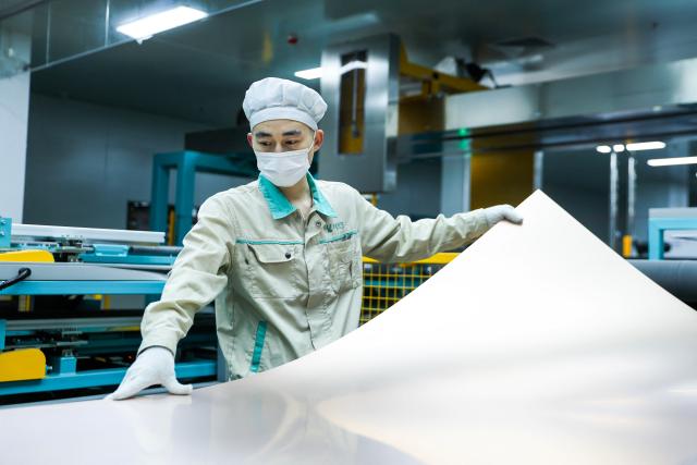A man works on the production of electronic circuit base materials for high-performance computing, AI servers, 5G communications, and aerospace applications at Jiangxi Shengyi Technology in Jiujiang, central China's Jiangxi province on November 20, 2025. (Photo by AFP) / China OUT