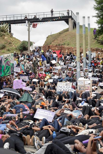 Protesters hold placards as they lie on the ground during the Women's Nationwide Shutdown at Constitution Hill in Johannesburg on November 21, 2025, ahead of the G20 leaders' Summit. Women for Change calls on the community across South Africa to refrain from all paid and unpaid work in workplaces, universities, and homes, and to spend no money for the entire day to demonstrate the economic and social impact of their absence, and demand that gender-based violence and femicide be declared a national disaster. (Photo by GIANLUIGI GUERCIA / AFP)