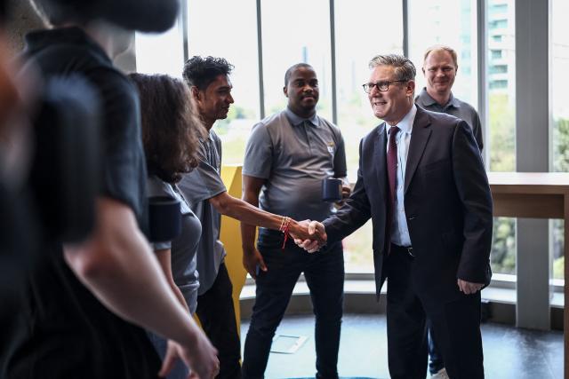 Britain's Prime Minister Keir Starmer (2nd R) greets apprentices during a reception at EY headquarters in Johannesburg, on November 21, 2025 ahead of the G20 leaders' Summit. (Photo by HENRY NICHOLLS / POOL / AFP)