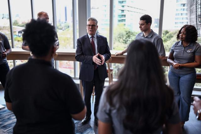 Britain's Prime Minister Keir Starmer (C) speaks to apprentices during a reception at EY headquarters in Johannesburg, on November 21, 2025 ahead of the G20 leaders' Summit. (Photo by HENRY NICHOLLS / POOL / AFP)