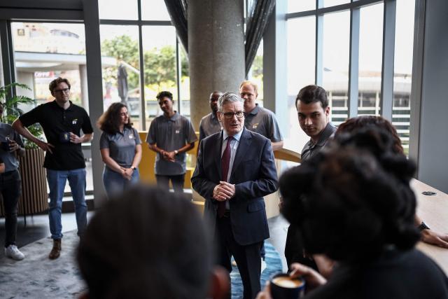 Britain's Prime Minister Keir Starmer (C) speaks to apprentices during a reception at EY headquarters in Johannesburg, on November 21, 2025 ahead of the G20 leaders' Summit. (Photo by HENRY NICHOLLS / POOL / AFP)