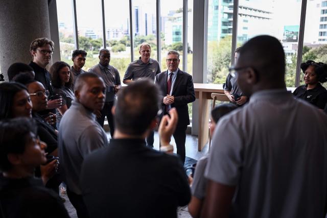 Britain's Prime Minister Keir Starmer (C) speaks to apprentices during a reception at EY headquarters in Johannesburg, on November 21, 2025 ahead of the G20 leaders' Summit. (Photo by HENRY NICHOLLS / POOL / AFP)