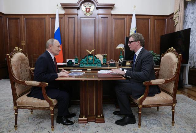 In this pool photograph distributed by the Russian state agency Sputnik, Russia's President Vladimir Putin meets with the Head of the Federal Tax Service (FTS) Daniil Yegorov in Moscow on November 21, 2025. (Photo by Gavriil Grigorov / POOL / AFP)