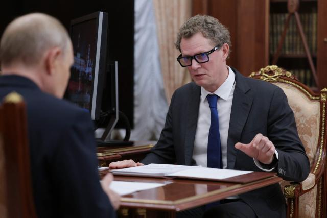 In this pool photograph distributed by the Russian state agency Sputnik, Russia's President Vladimir Putin meets with the Head of the Federal Tax Service (FTS) Daniil Yegorov in Moscow on November 21, 2025. (Photo by Gavriil Grigorov / POOL / AFP)