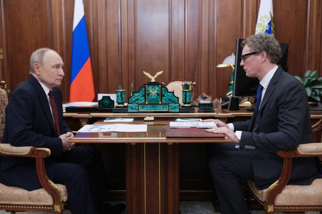 In this pool photograph distributed by the Russian state agency Sputnik, Russia's President Vladimir Putin meets with the Head of the Federal Tax Service (FTS) Daniil Yegorov in Moscow on November 21, 2025. (Photo by Gavriil Grigorov / POOL / AFP)