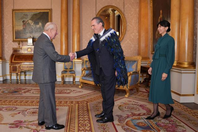 Britain's King Charles III greets Hamish Cooper, High Commissioner for New Zealand, and his partner Misako Kitaoka, during an audience at Buckingham Palace in London on November 21, 2025. (Photo by Yui Mok / POOL / AFP)