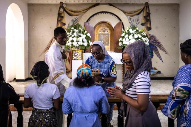 (FILES) A nun imparts the holy communion to Catholics attending a mass at the Church of the Assumption in Lagos on April 21, 2025. An unknown number of pupils have been abducted from a Catholic school in central Nigeria, an official said on November 21, 2025, in the second such incident in less than a week. (Photo by OLYMPIA DE MAISMONT / AFP)