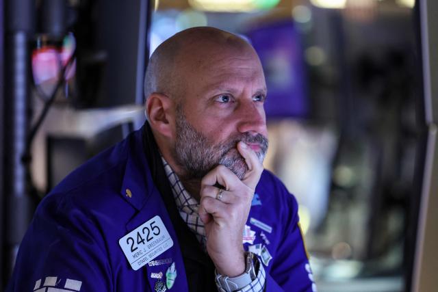 A Trader works on the floor of the New York Stock Exchange (NYSE) in New York on November 21, 2025. Wall Street stocks rebounded early Friday after a Federal Reserve official's remarks reignited hopes of a third consecutive US interest rate cut in December. (Photo by ANGELA WEISS / AFP)