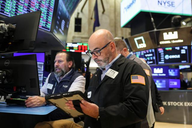 Traders work on the floor of the New York Stock Exchange (NYSE) in New York on November 21, 2025. Wall Street stocks rebounded early Friday after a Federal Reserve official's remarks reignited hopes of a third consecutive US interest rate cut in December. (Photo by ANGELA WEISS / AFP)